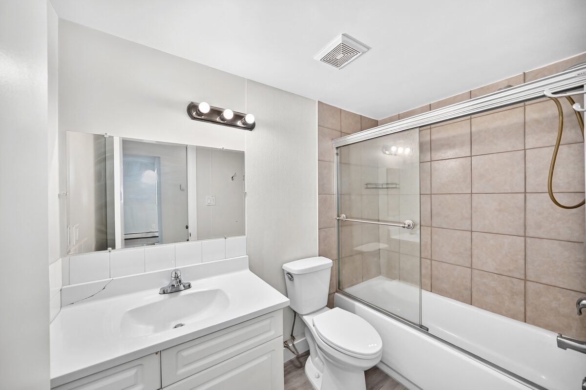Renovated bathroom with vanity and tiled tub surround