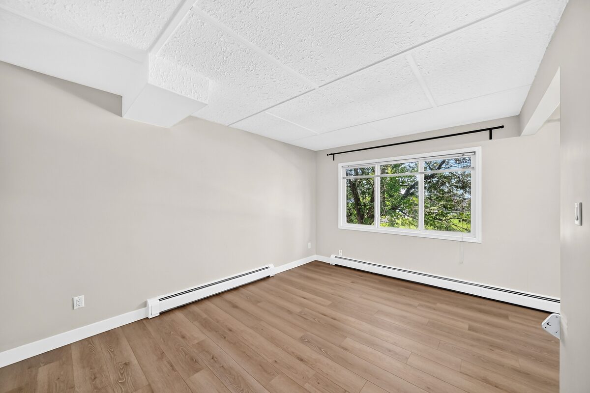 Bright bedroom with window and vinyl-plank flooring