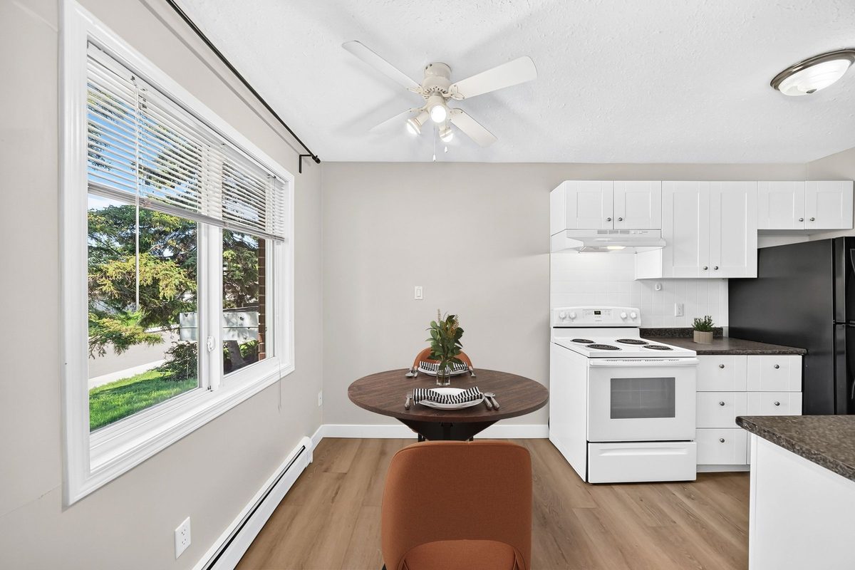 Virtually staged dining nook beside the kitchen with large window