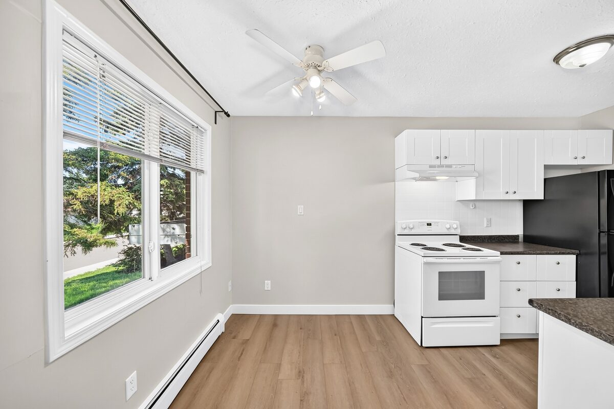 Bright living and dining area with large window and updated kitchen